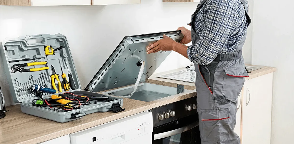 Handyman repairing a cooktop and checking wiring connections in Knoxville, TN